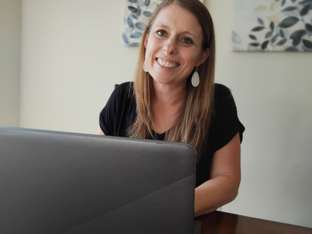 Jill smiling at her laptop